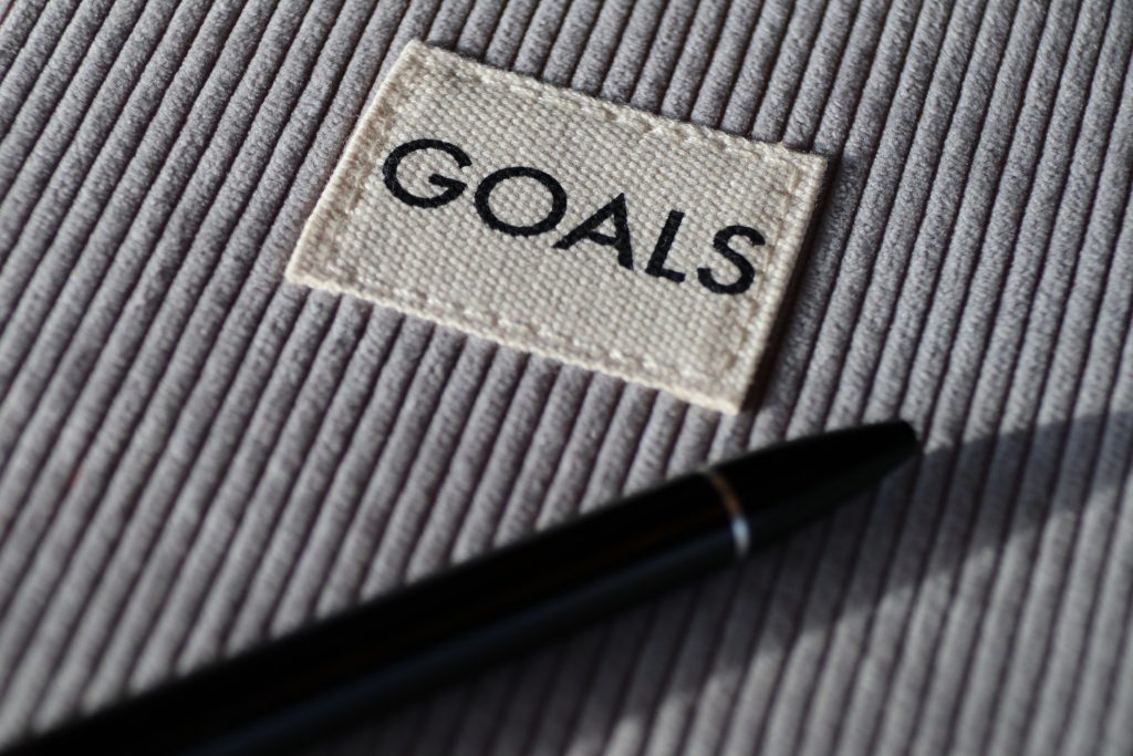 Auf dem Bild ist ein Textilstück mit dem Aufnäher mit der Aufschrift "Goals" zu sehen.